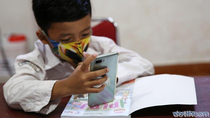 Siswa siswi menggunakan fasilitas WiFi gratis saat mengikuti kegiatan pembelajaran jarak jauh di balai warga RW 05 Kelurahan Kuningan Barat, Mampang Prapatan, Jakarta, Jumat (27/8/2020). WiFi gratis ini disediakan oleh swadaya warga RW 05 guna membantu anak-anak yang melakukan pembelajaran jarak jauh yang terkendala dengan kuota internet.